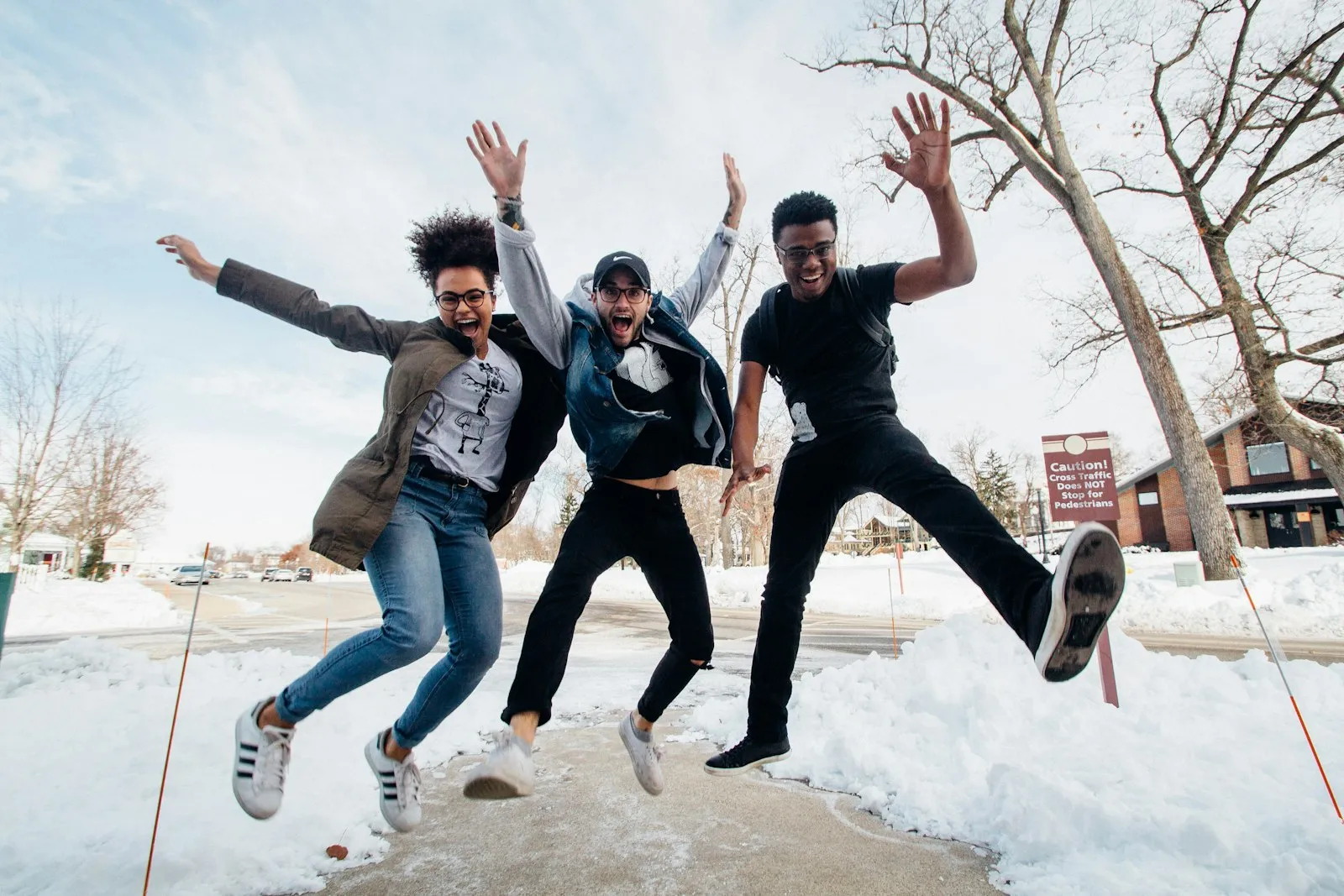 Three friends jumping in the air together outdoors
